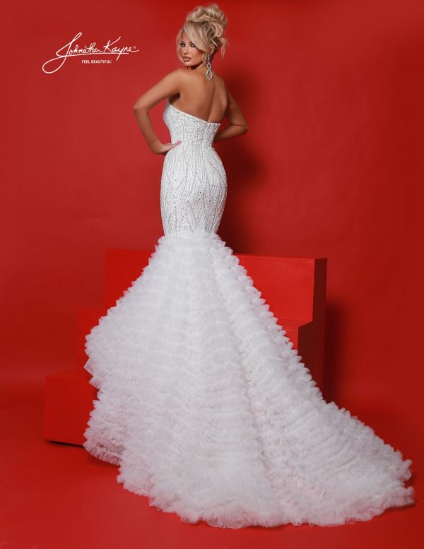 White mermaid gown showcasing sculpted fit and voluminous layered ruffled train. Perfect for pageants, red carpet events, homecoming court, destination wedding, bridal looks, and stage presence.